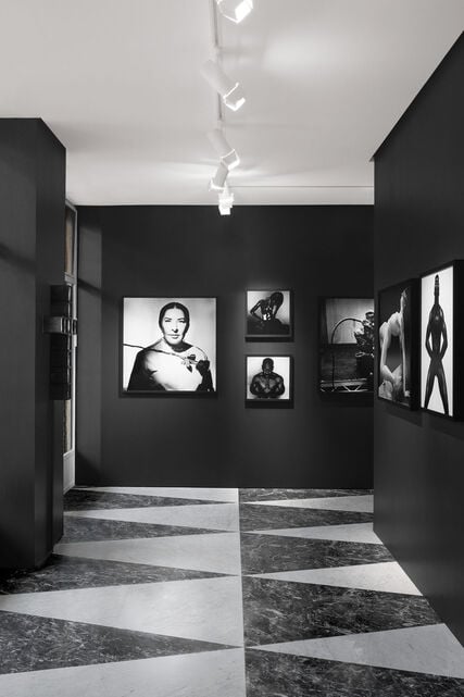 An exhibition place with green-teal background, showcasing sculptures made by Peter Schlesinger.