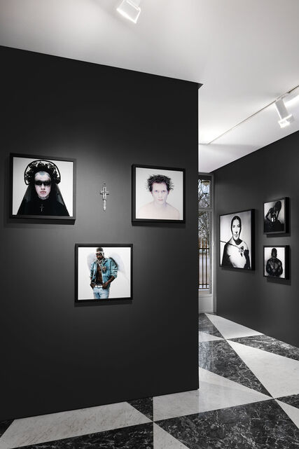 An exhibition place with green-teal background, showcasing a beige massive sculpture made by Peter Schlesinger.