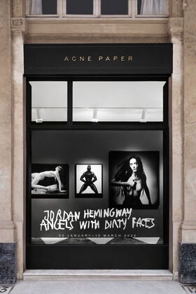 Exterior window of the Acne Paper Palais Royal gallery space in Paris, presenting the permanent gallery that merges fashion, art, and publishing beneath the Palais Royal arcades.