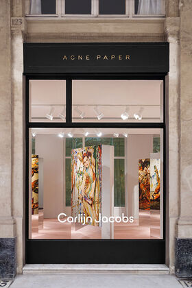 Exterior window of the Acne Paper Palais Royal gallery space in Paris, presenting the permanent gallery that merges fashion, art, and publishing beneath the Palais Royal arcades.