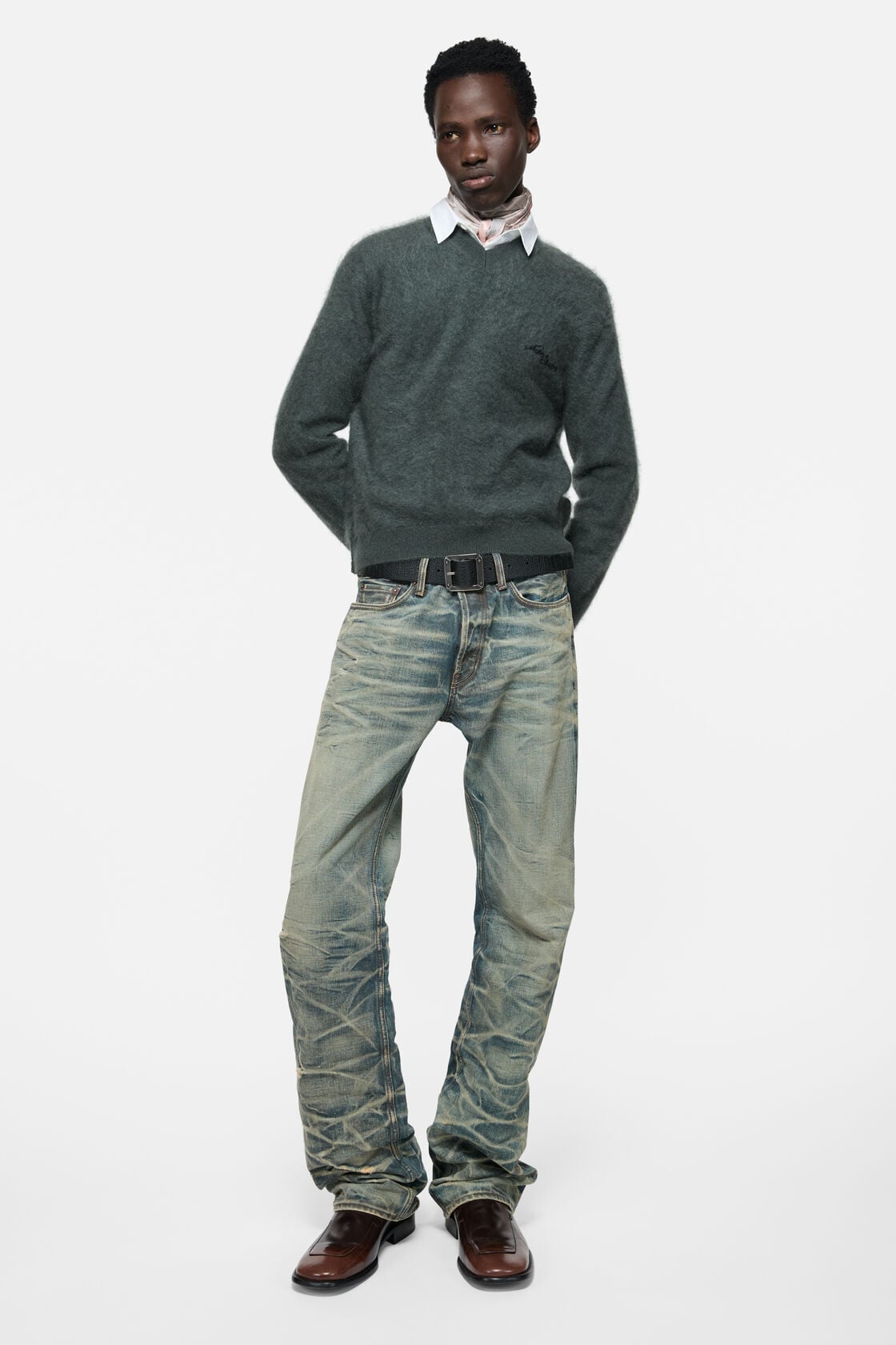 Acne Studios dark green cashmere v-neck sweater with fuzzy texture, worn over a white shirt with a scarf, paired with distressed jeans and brown