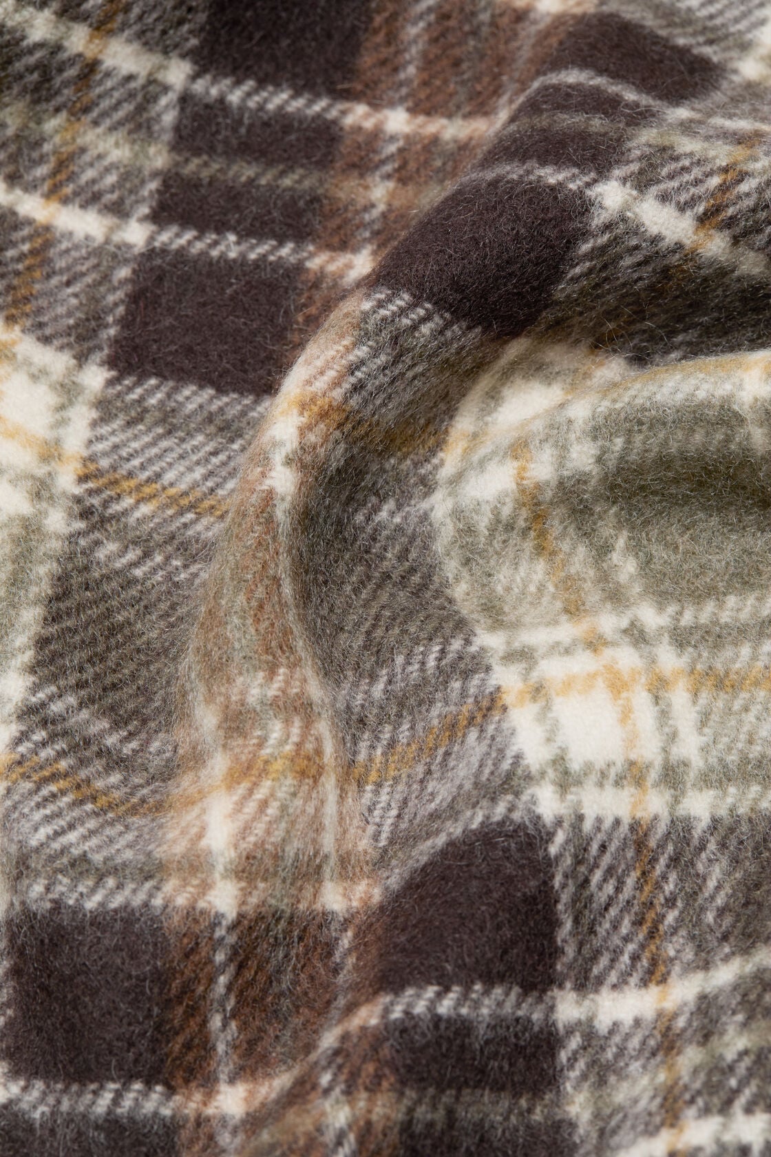Close-up of an Acne Studios cashmere scarf in a dark brown and khaki green plaid check pattern with cream and mustard tones.