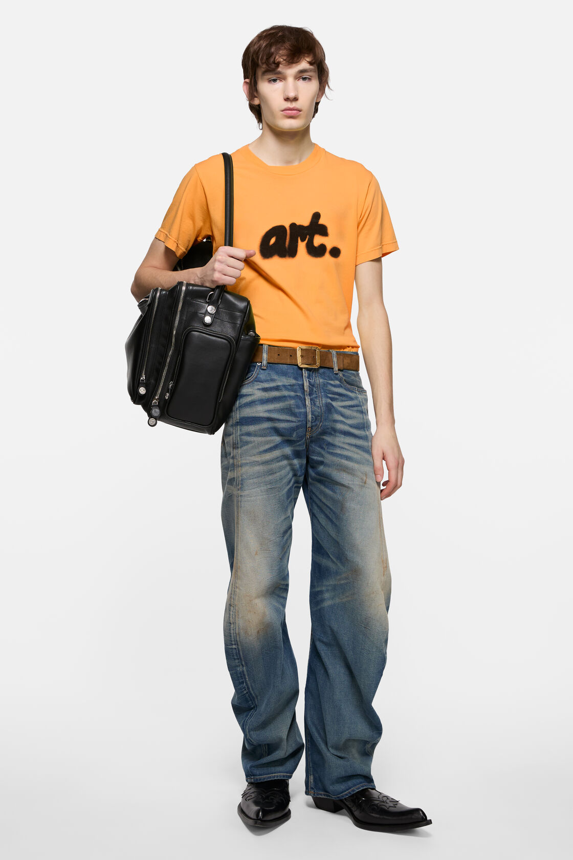 Acne Studios sprayed graphic t-shirt in saffron yellow cotton jersey with black 'art.' print on chest, worn with blue distressed jeans and a black