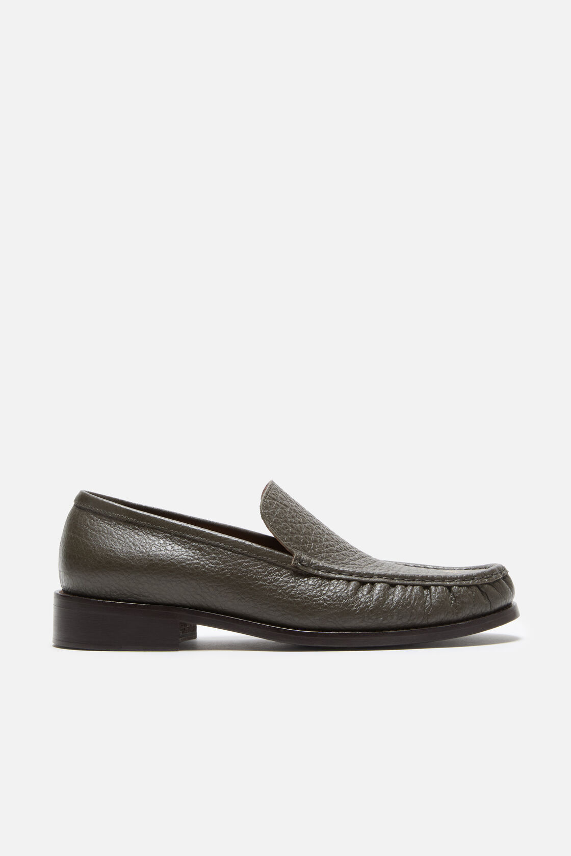 Acne Studios khaki green grained leather loafer with moccasin toe, slip-on silhouette, and dark flat sole, shown in profile.