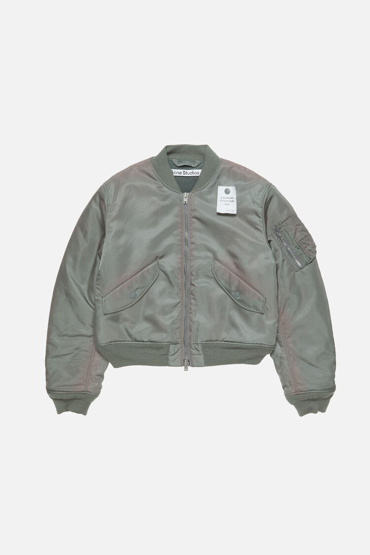 Acne Studios stone grey washed bomber jacket in recycled nylon with ribbed trim, flap pockets, and sleeve zip pocket.