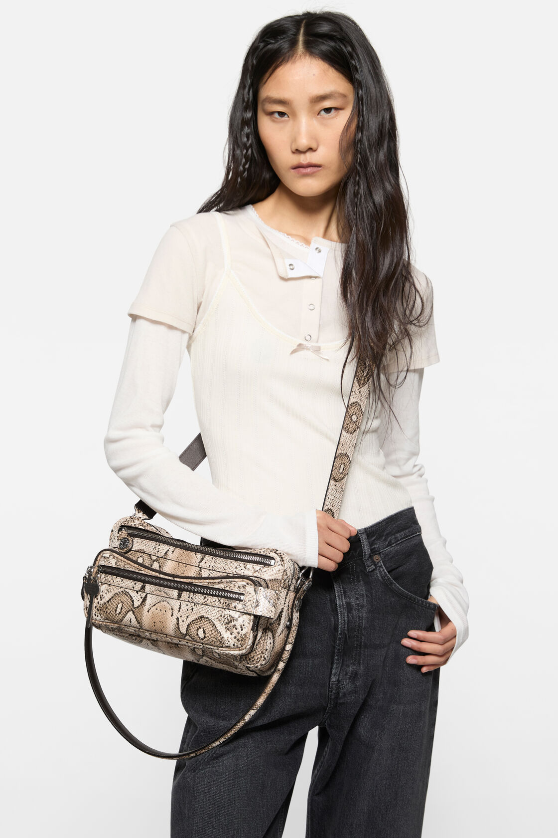Acne Studios small shoulder bag in beige multi snake-print leather with a top handle, zip closure, front snap pocket, and detachable crossbody strap.
