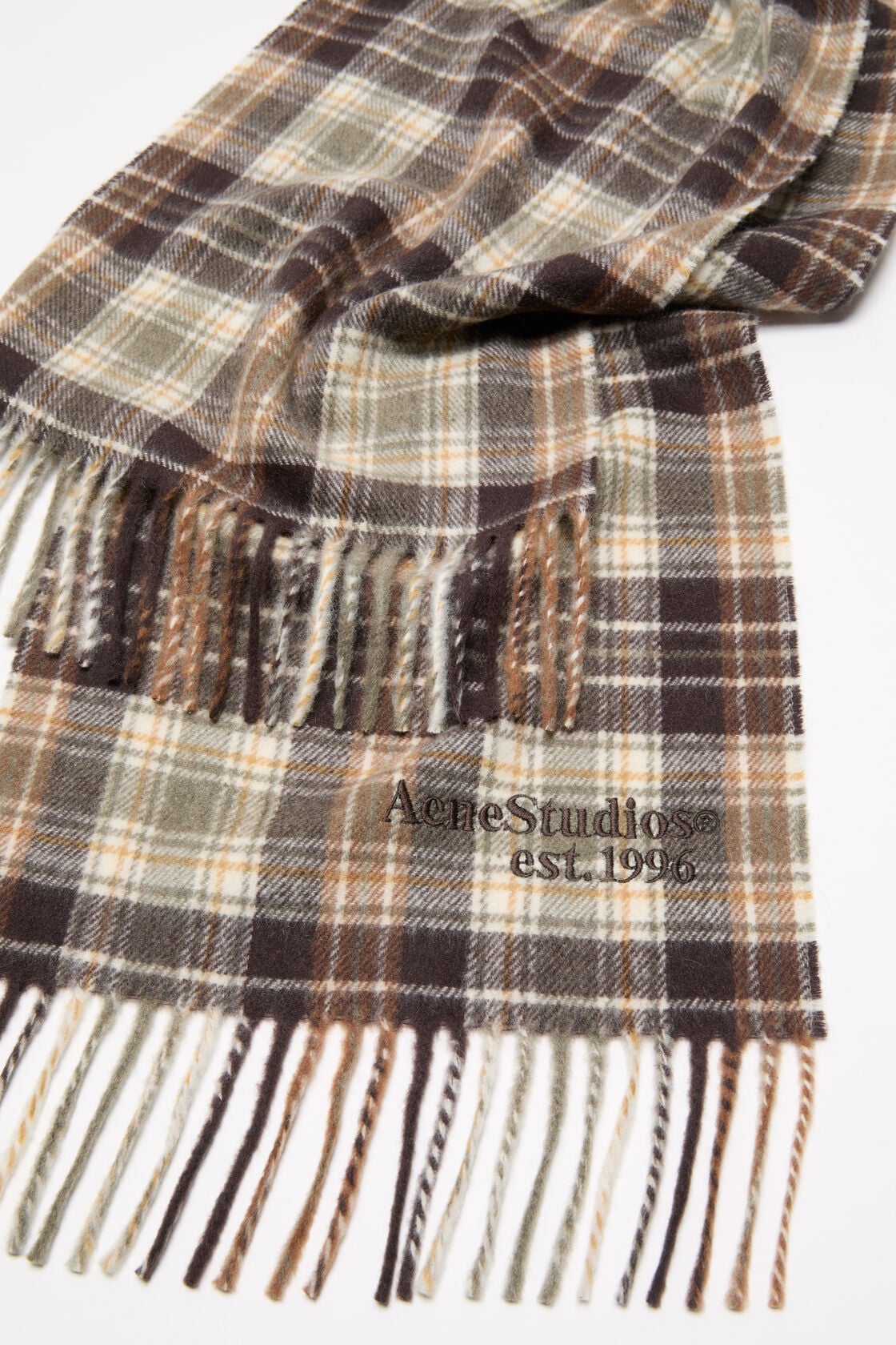 Acne Studios cashmere scarf in dark brown and khaki green plaid check, with fringed ends and embroidered logo.