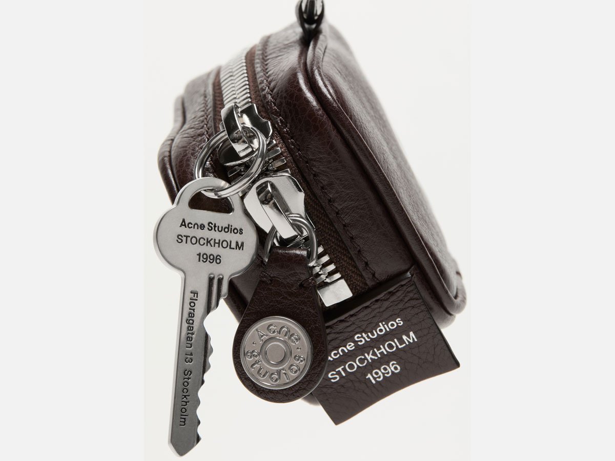 A close-up of the Acne Studios mini leather Camero bag in brown, with silver details.