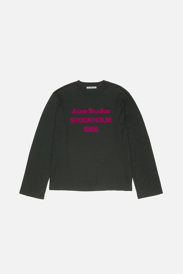 A showcase of the product of Acne Studios black long-sleeved t-shirt with fuschia logo on it.