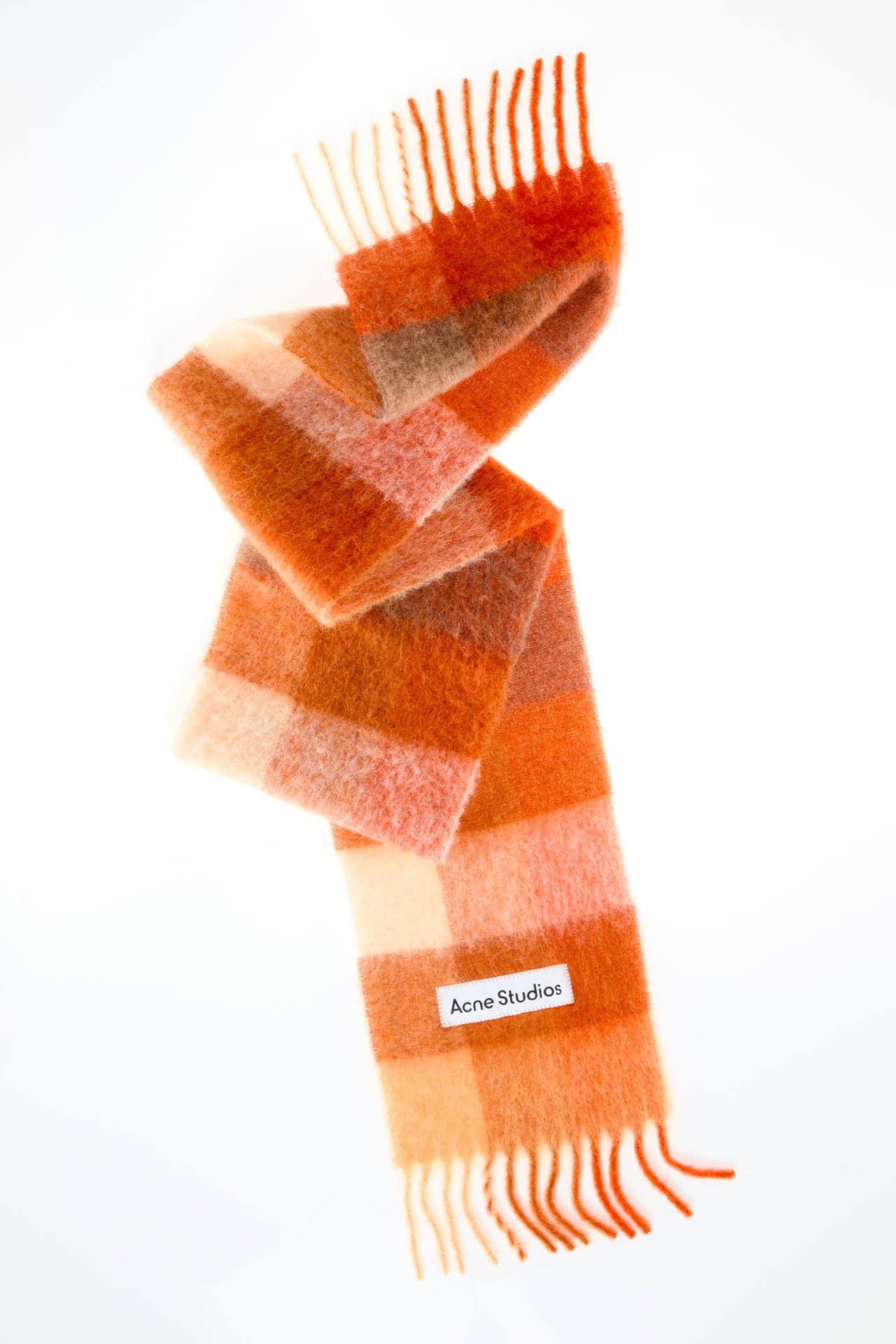 A creative image of an Acne Studios mohair checked scarf in bright orange.