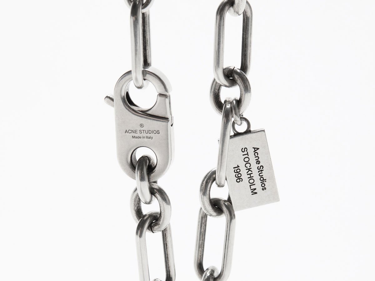 A close-up of the Acne Studios chunky silver necklace.