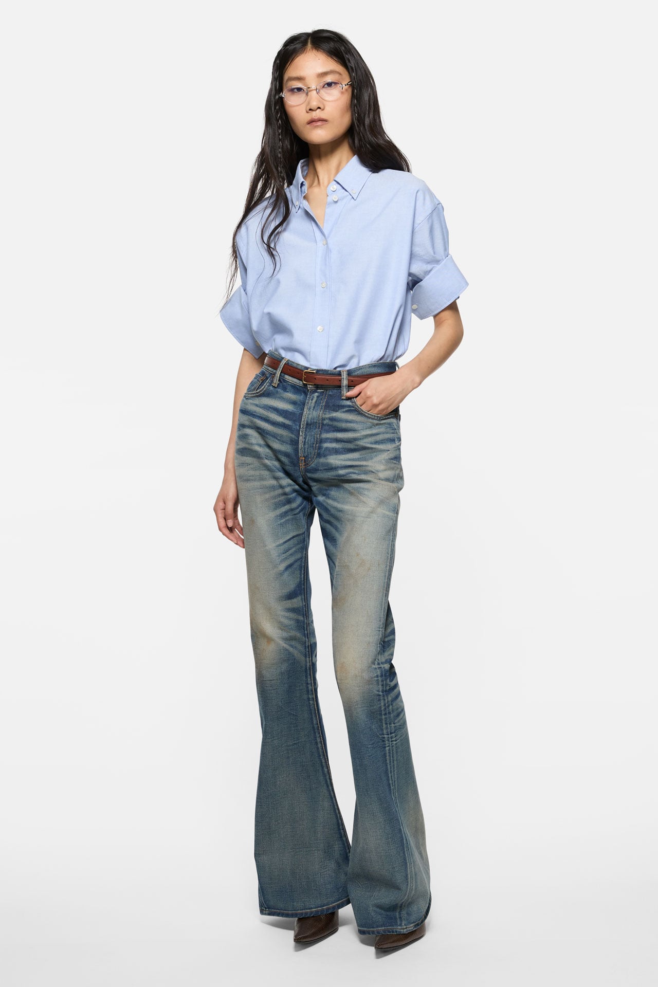 Acne Studios Womenswear brown oversized piké t-shirt with checked skirt, camel brown leather bag and yellow leather high-heels.
