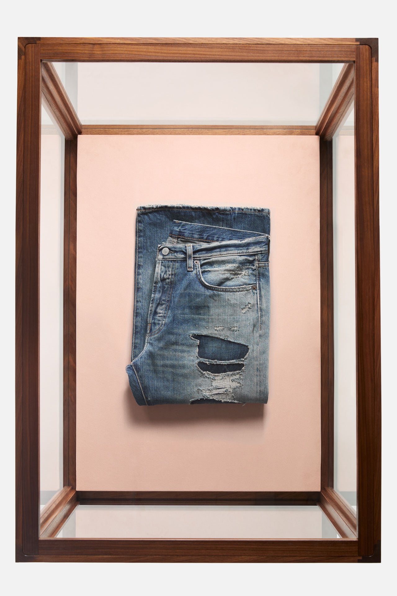 Acne Studios regular fit blue jeans with ripped details folded in a glass box.