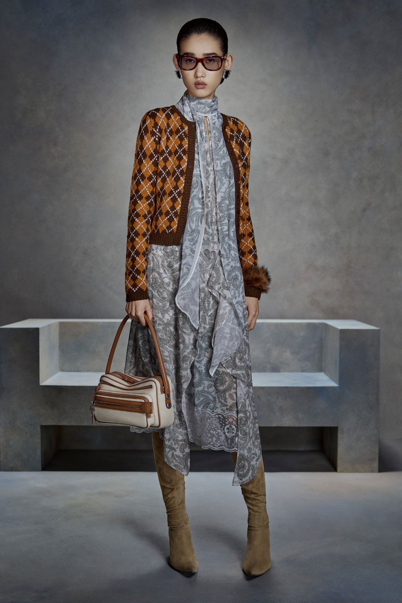 Acne Studios light blue silk blouse with matching skirt, taupe suede boots, orange-brown knitted cardigan and a beige canvas Camero bag.