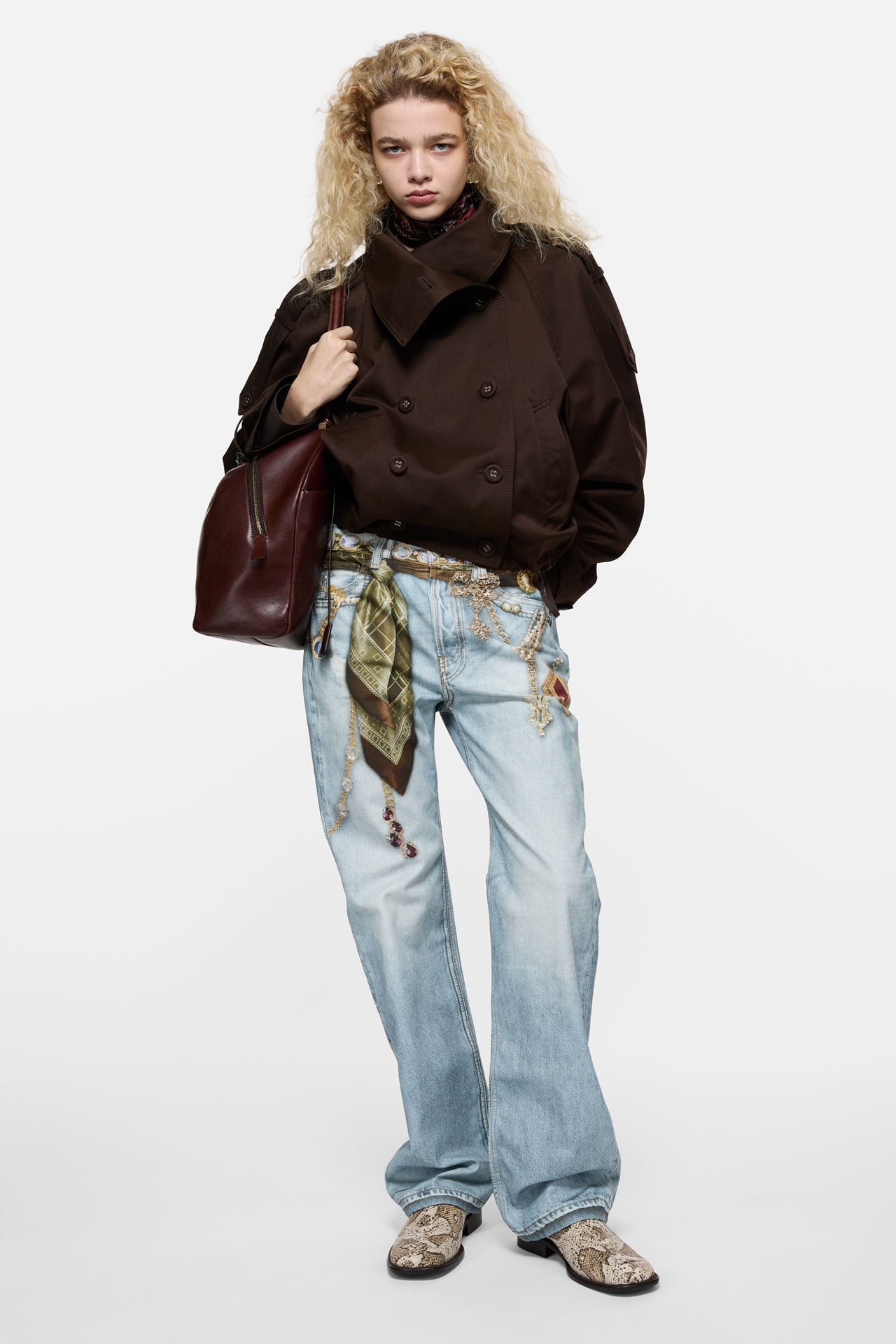 Acne Studios printed cotton canvas jeans in light blue color, brown cropped jacket and a burgundy leather bag.