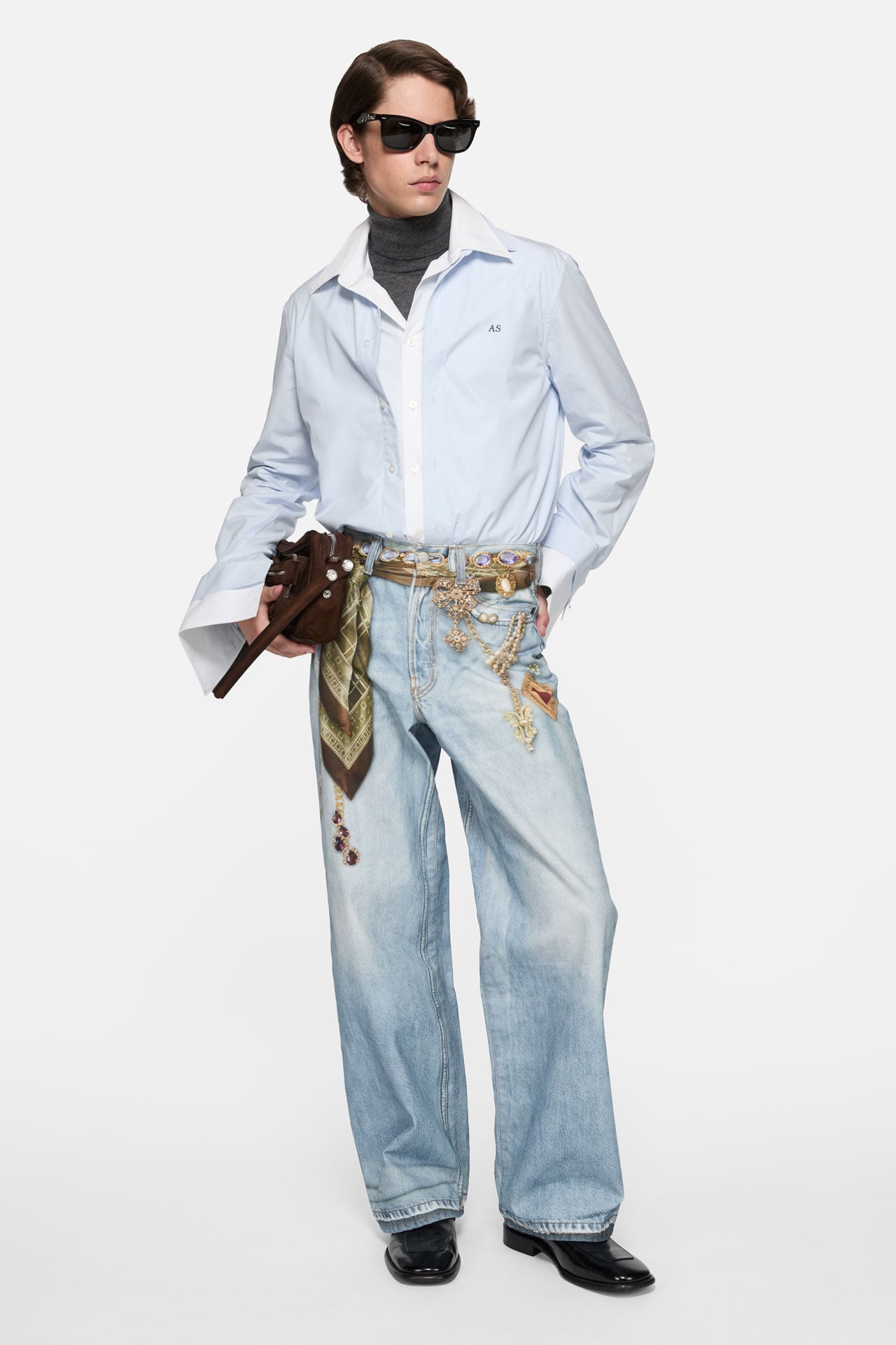 Acne Studios regular fit blue jeans with a light blue shirt and holding a brown leather Camero Party bag.