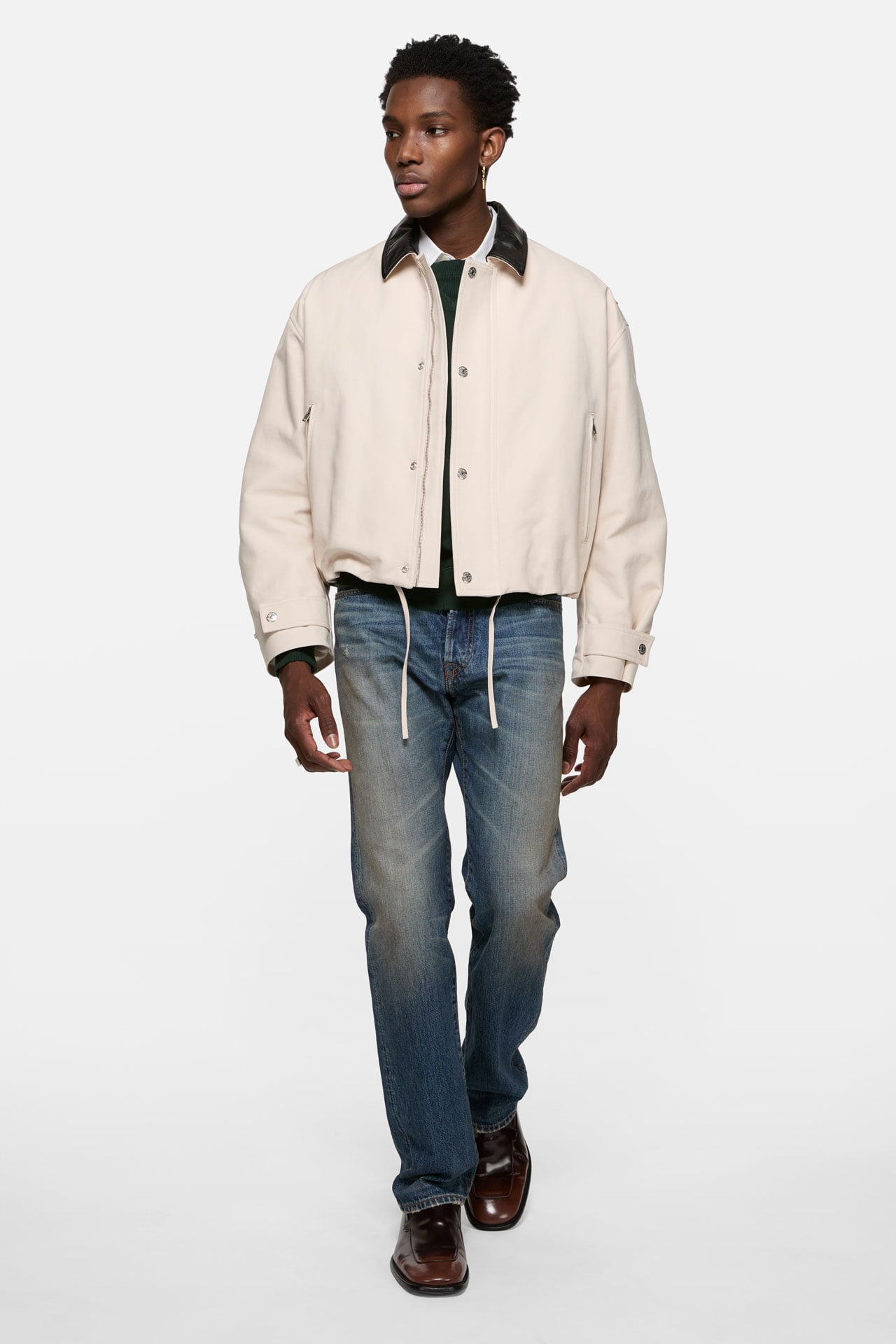 Acne Studios indigo blue regular fit jeans, worn with a white bomber jacket.