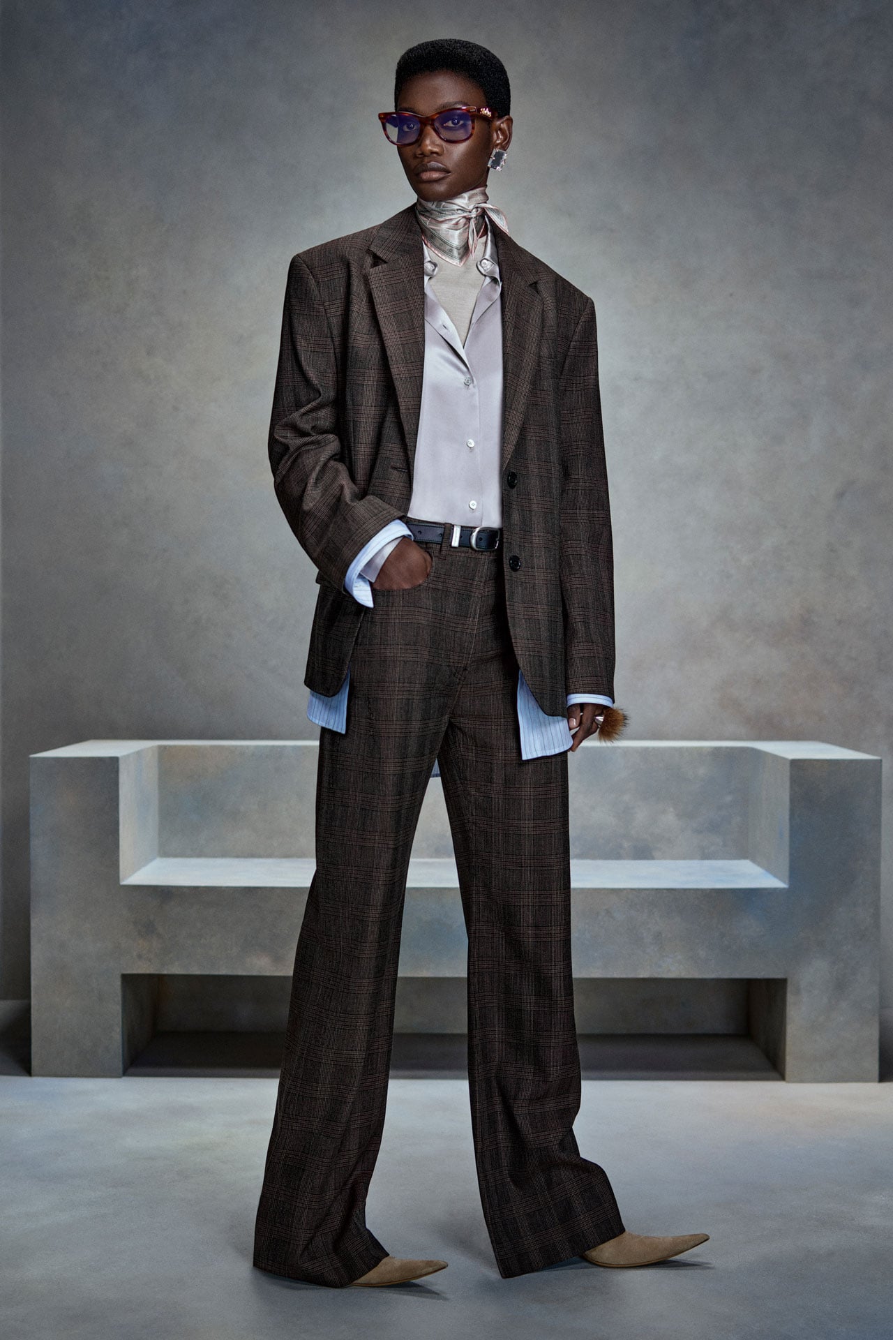 Acne Studios dark grey/ brown matching suit jacket and tailored pants set, light grey silk shirt and sunglasses.