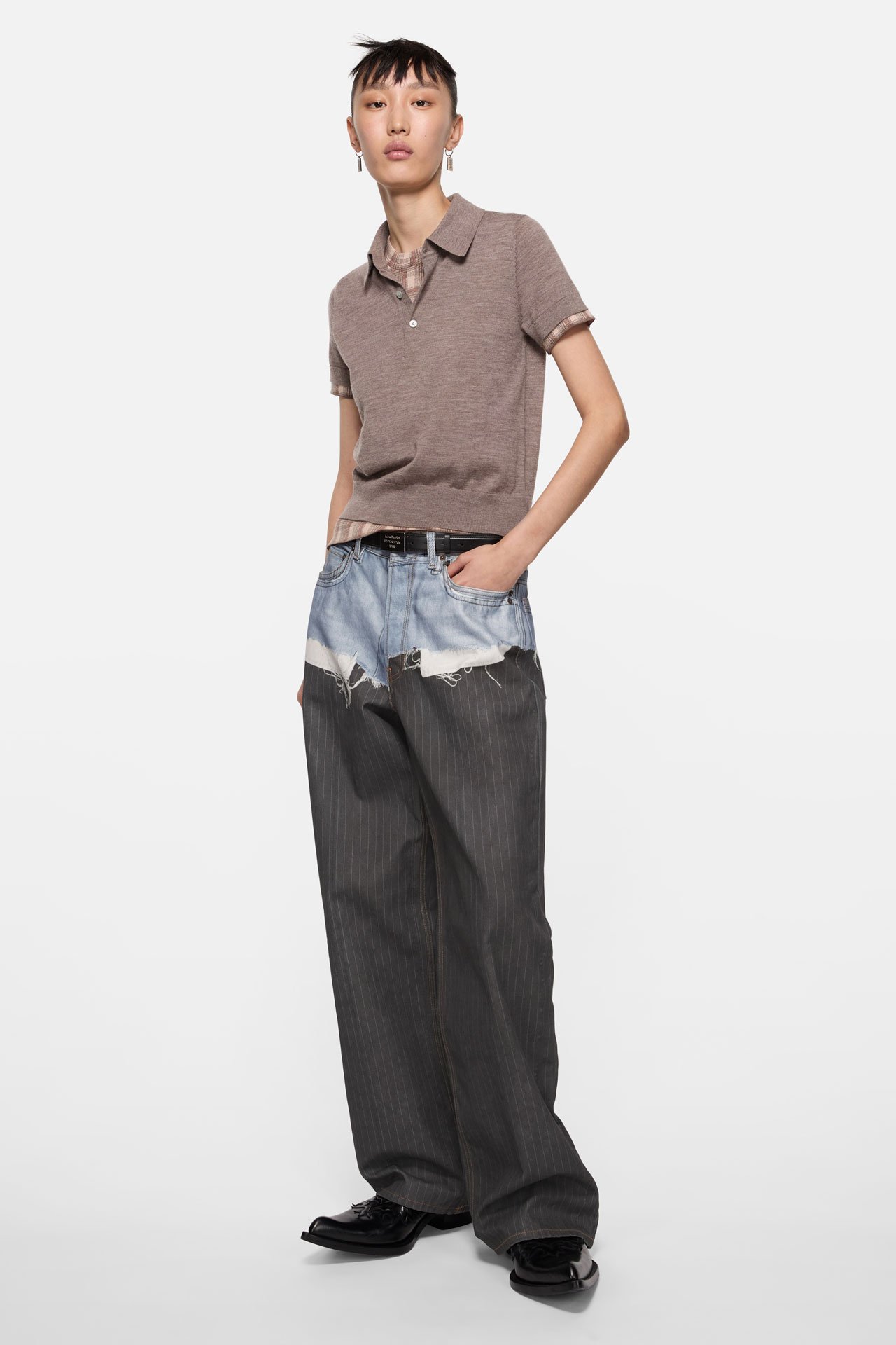 A female model wearing a pair of Acne Studios jeans and brown t-shirt.
