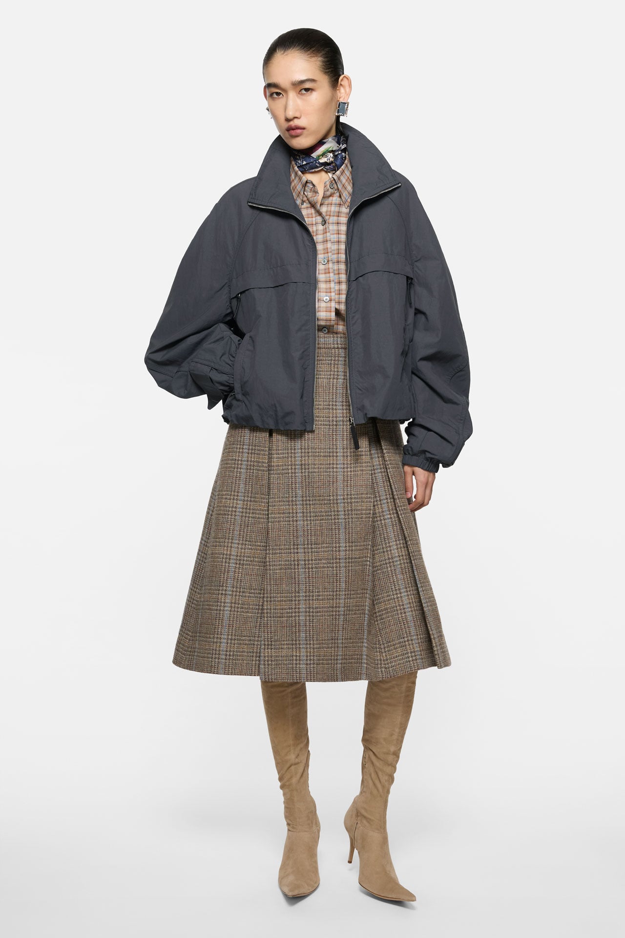 Acne Studios Womenswear grey jacket, brown checked skirt and beige suede high-heel high boots.