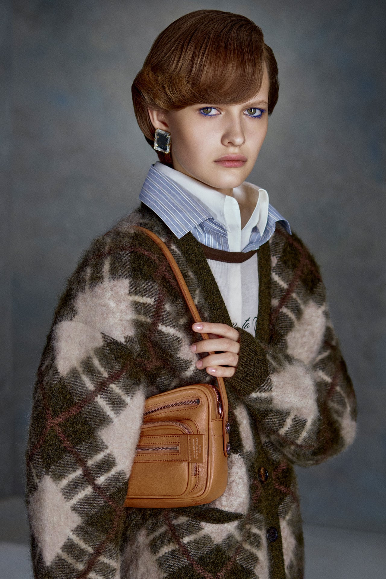 Acne Studios Womenswear green and white checked knitted cardigan, blue shirt and a brown leather Camero bag.