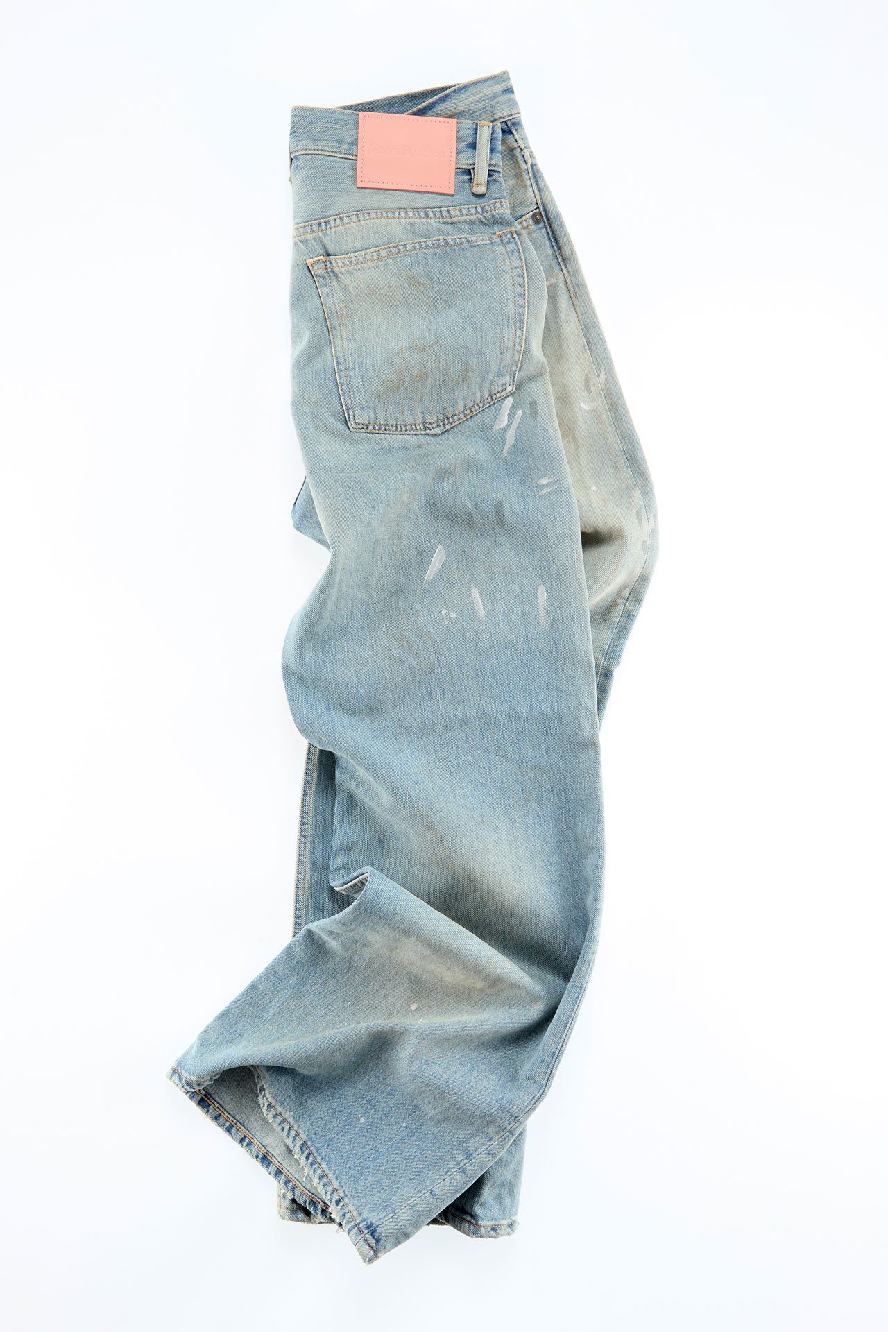 A creative showcase of a pair of light-blue jeans, presented folded.