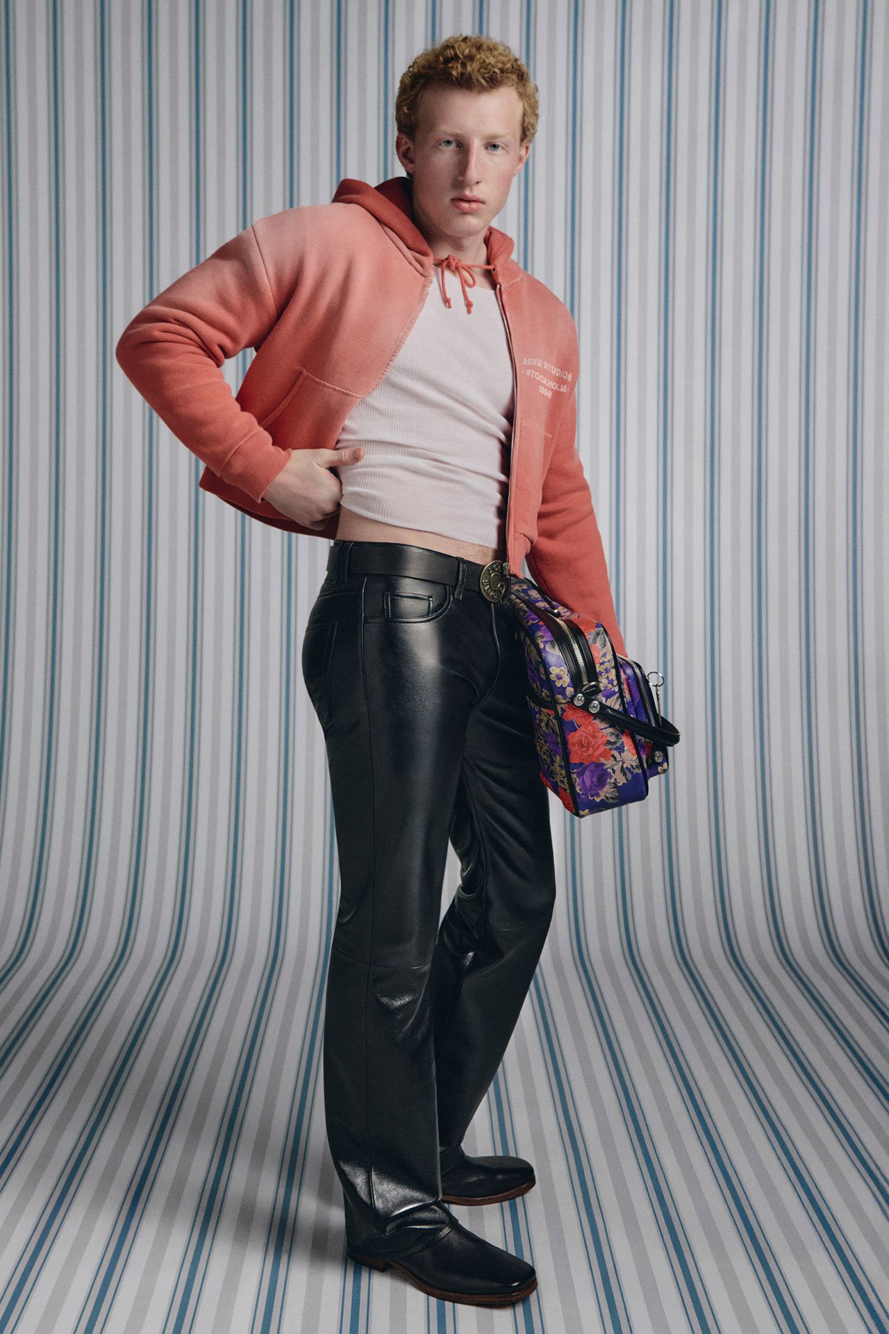 A female model wearing a long-sleeve green t-shirt and beige jeans.