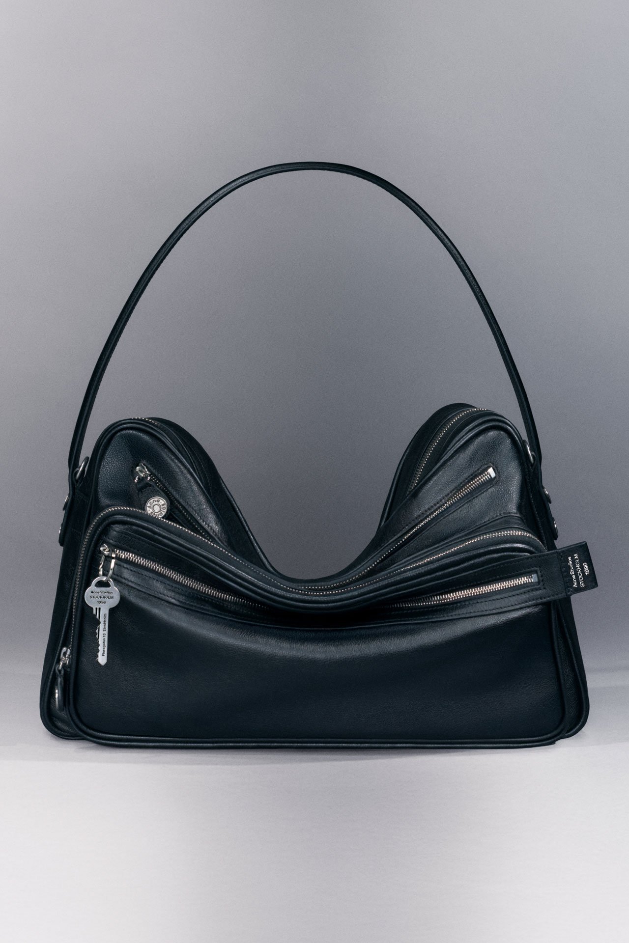 Acne Studios Camero Camera black leather shoulder bag with a multi-pocket design.