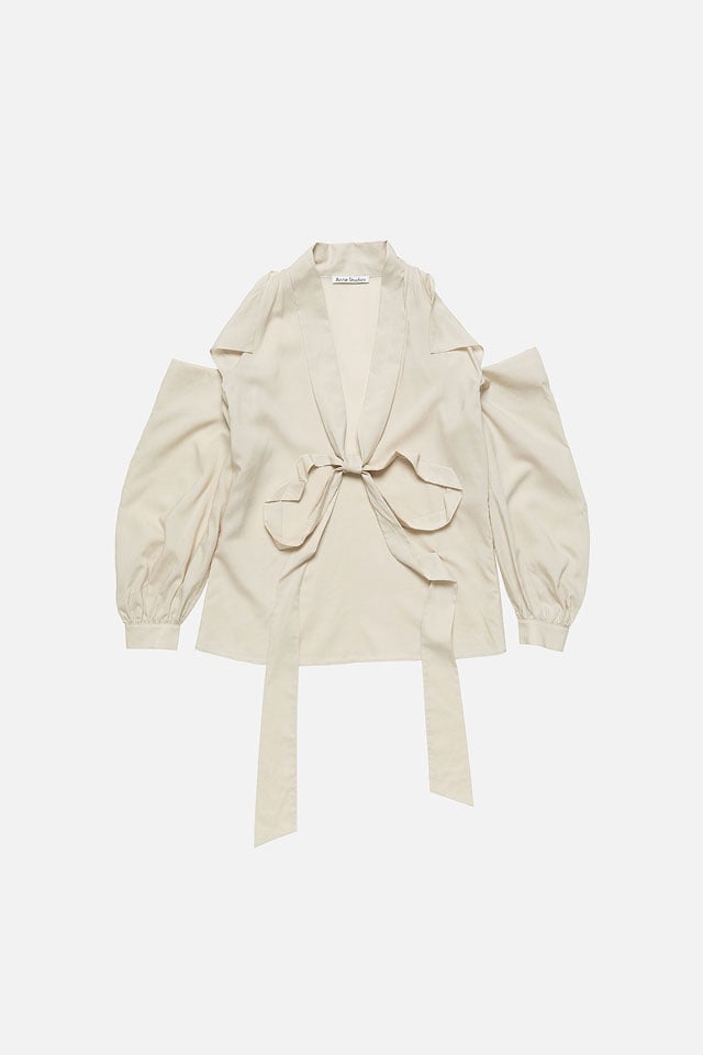 A showcase of the product: Acne Studios light beige cut-out blouse with bow.